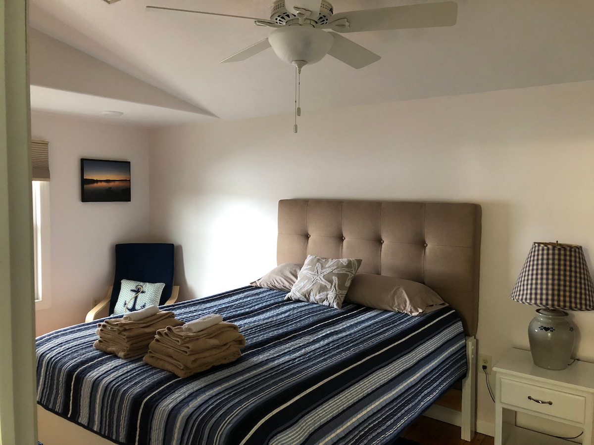 Slaapkamer 1: Hoofdslaapkamer met een queensize bed, plafondventilator en tv.