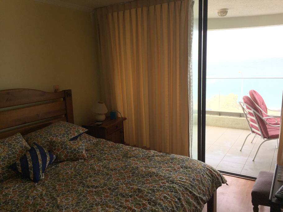 Dormitorio principal con vista al mar, TV y baño privado
