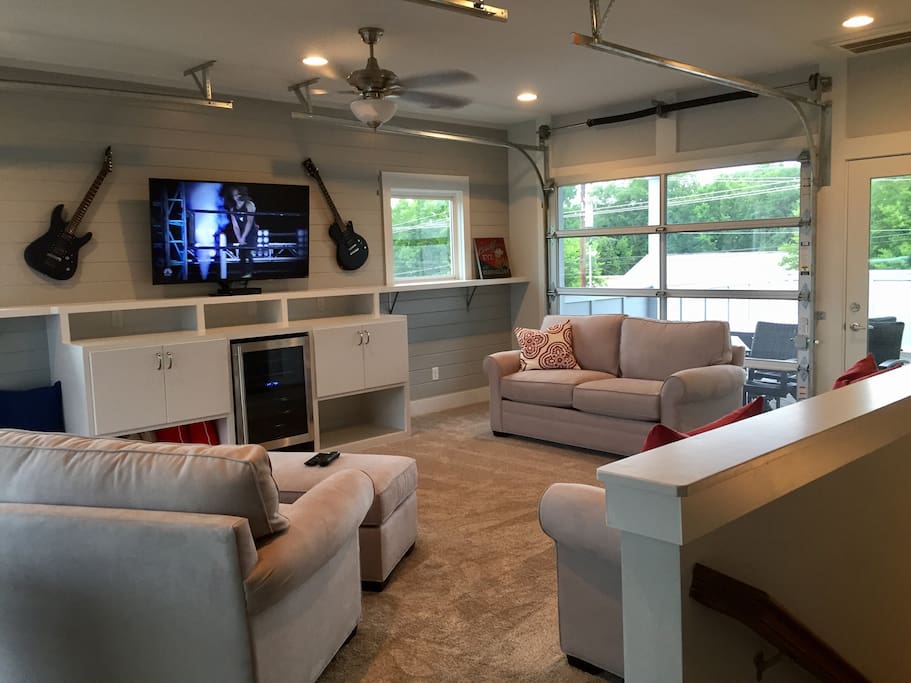 Third floor common area with bar and fridge. Two garage doors that open to two rooftop terraces. Sleeper sofa located in the best room in the house.