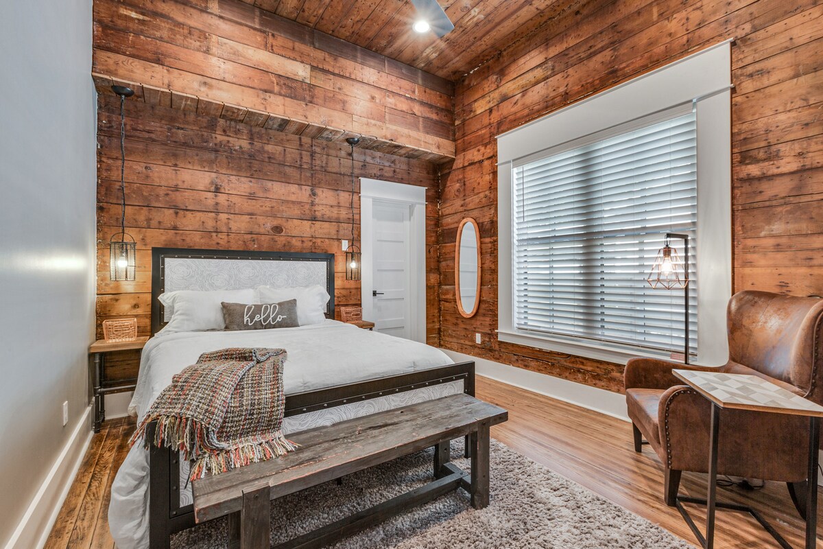 The industrial bedroom with queen bed and original shiplap, with connected private bath.