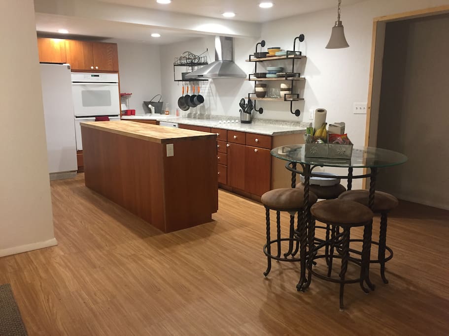 Kitchen with double oven, dishwasher, electric cooktop and butcher block island.