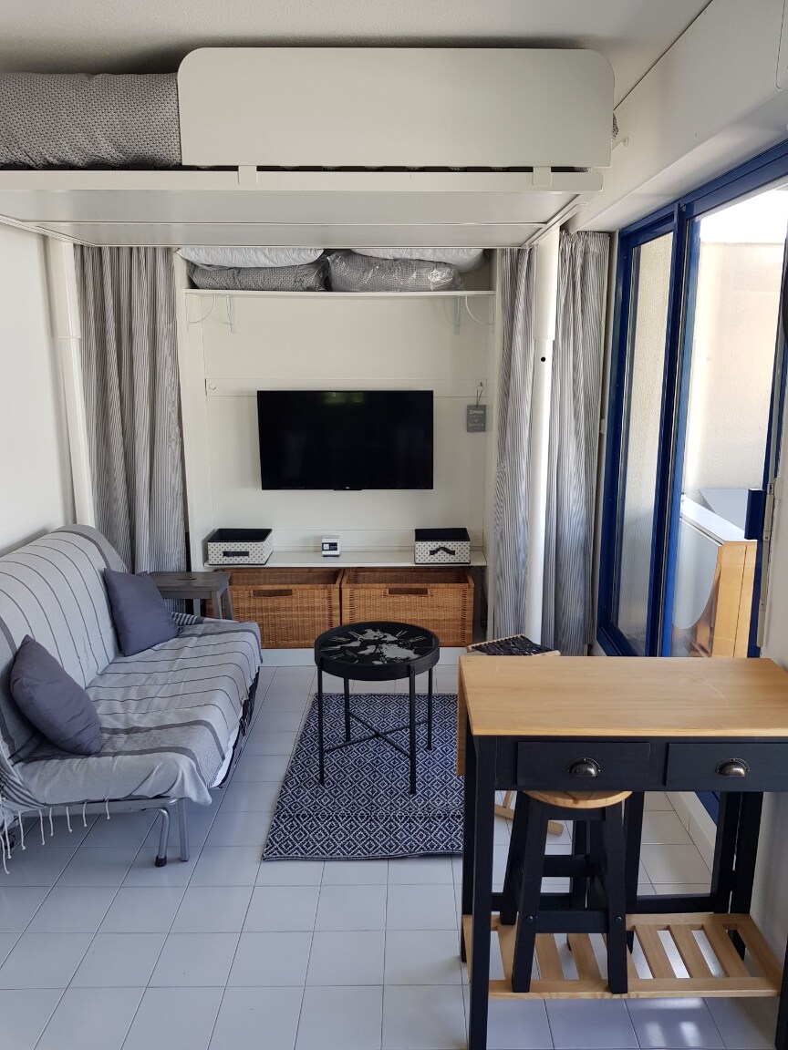 Living room with a bed for 2 people that goes up and down on jack in order to optimize the space.
A convertible BZ for 2 people. 
New duvet bedding and cushions.
 Flat screen.
Lounge table.
Miscellaneous storage.
Large bay windows with terrace access