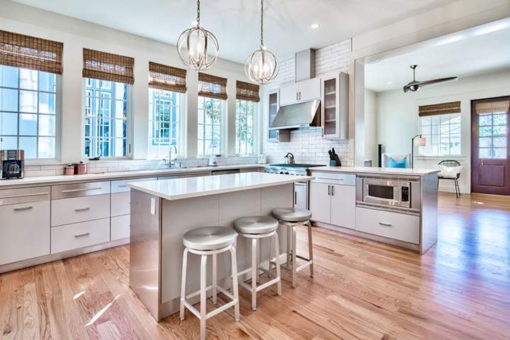 The modern kitchen has plenty of counter space and great lighting.
