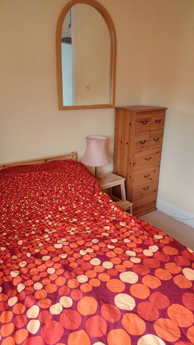 Bedroom with double bed and small chest of drawers.