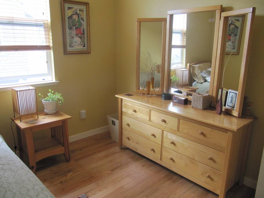 Large dresser with tri-fold mirror in bedroom to prepare for your day. Great morning light.