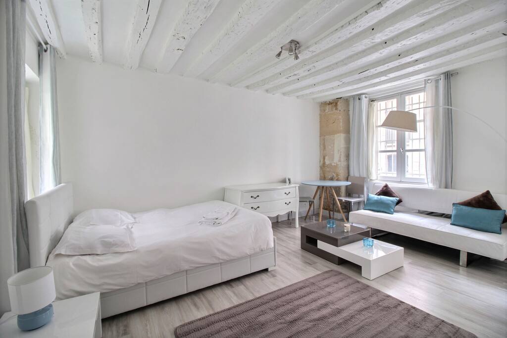 Living room with large double bed, sofa and TV
