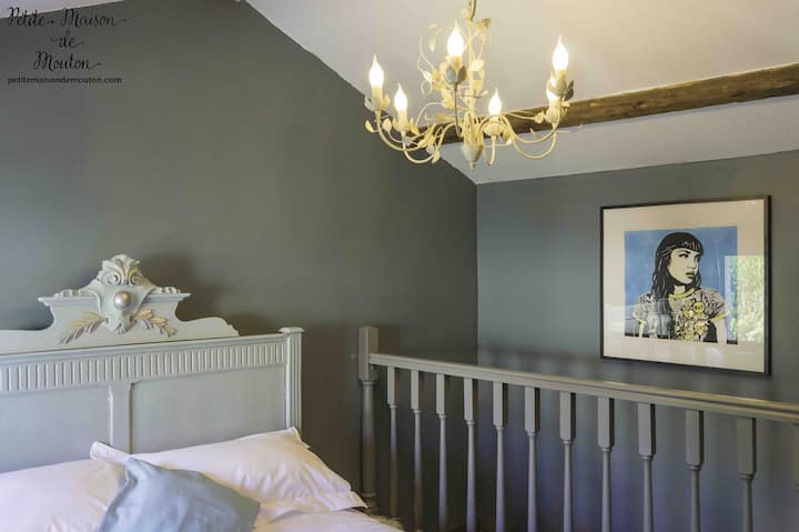 位于一楼的主卧室配有古董床、记忆海绵床垫和埃及棉床上用品。 Art by Gemma Compton