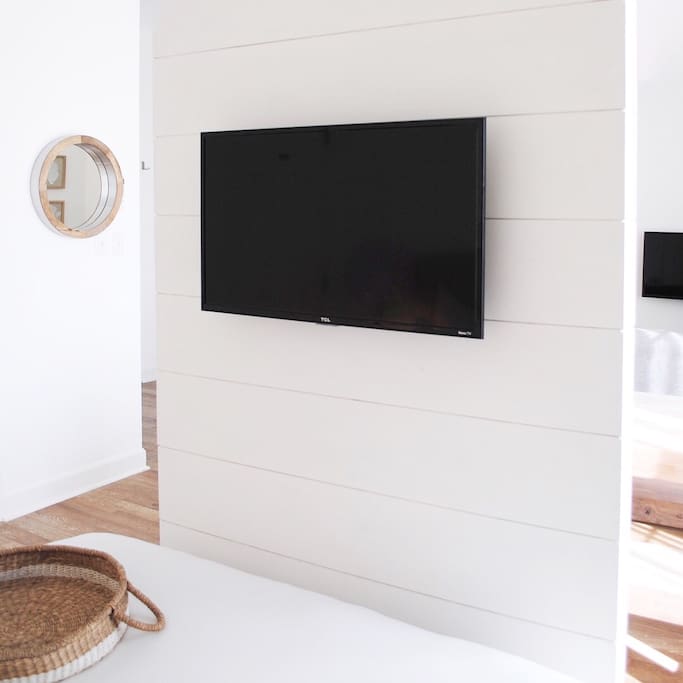 Room divider creates a sense of separation between bedroom and rest of the space. Smart TV offers different viewing options than just cable.