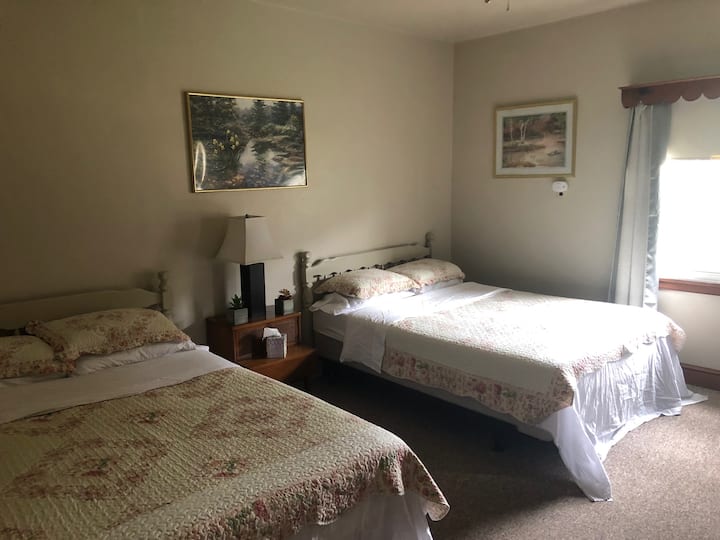 This bedroom features two Queen-sized beds, and an en suite bathroom.