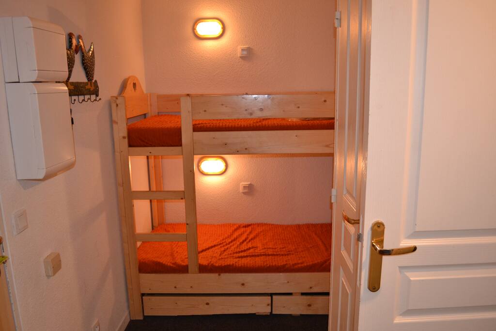 Entrée coin nuit avec 2 lits superposés séparé du séjour par une porte.