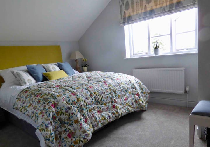 Spálňa 1 s manželskou posteľou King a dizajnérskymi látkami Voyage a mäkkým nábytkom od Snape Maltings.