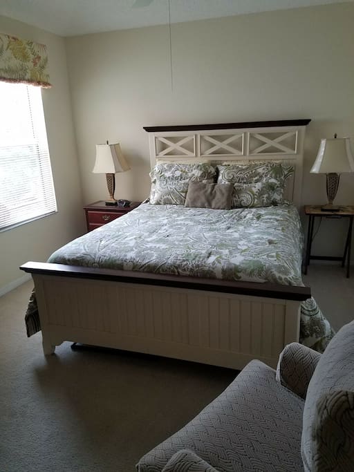 Second bedroom off the kitchen has a queen sized bed and private bathroom.
