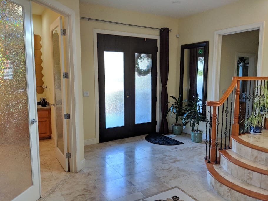 Just inside the front door, the floors are tiled travertine, granite, and marble. Your destination lies just up the stairs.