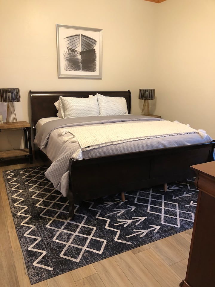 Cama king en la planta baja con ventilador de techo. 
