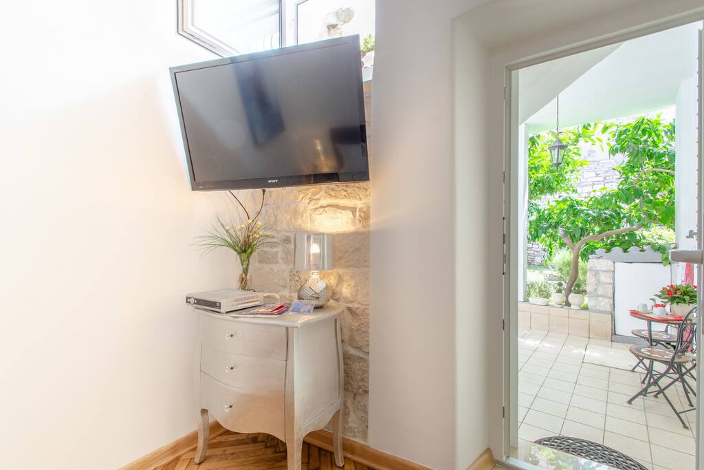 TV in bedroom with a view and entrance to the terrace