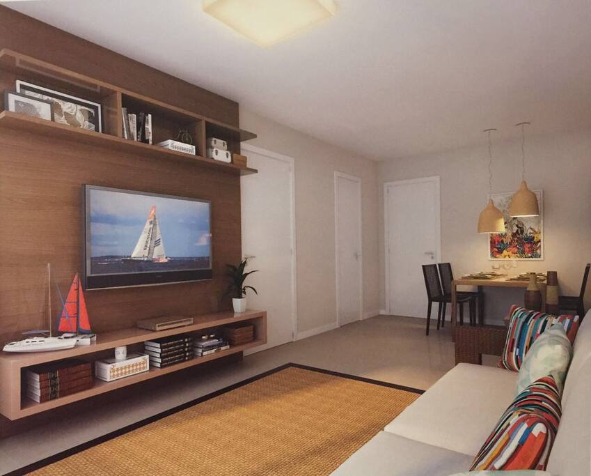 Sala confortável com televisão, cozinha americana, lavabo e ar condicionado .