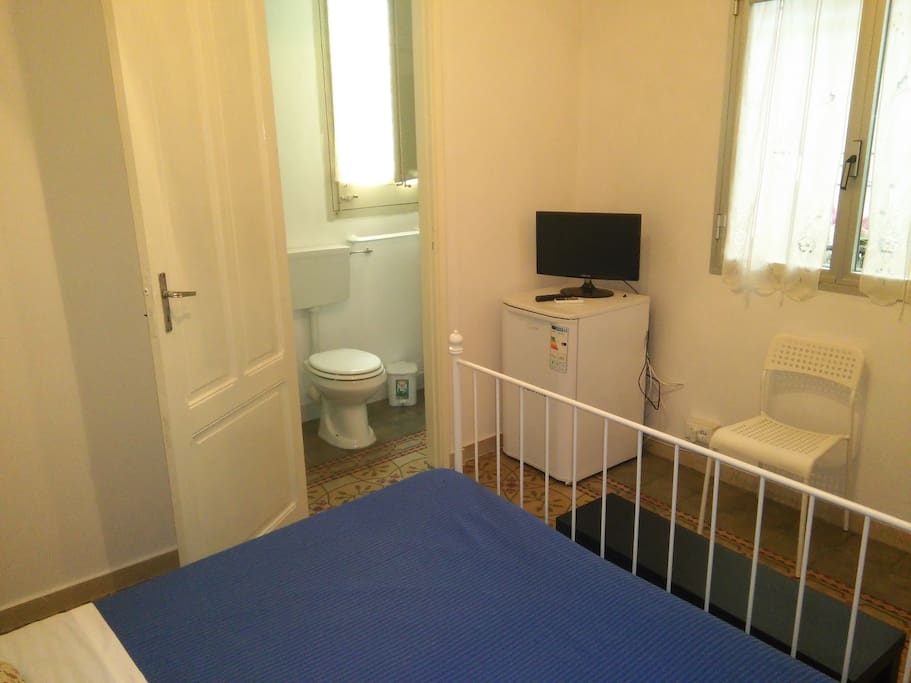 camera da letto matrimoniale con bagno, frigo e tv
