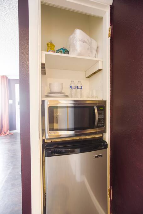 Mini Kitchenette w/ dishware mini-fridge and microwave.
