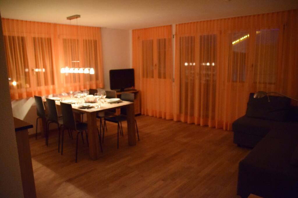 Wohnzimmer mit Esstisch bei Nacht