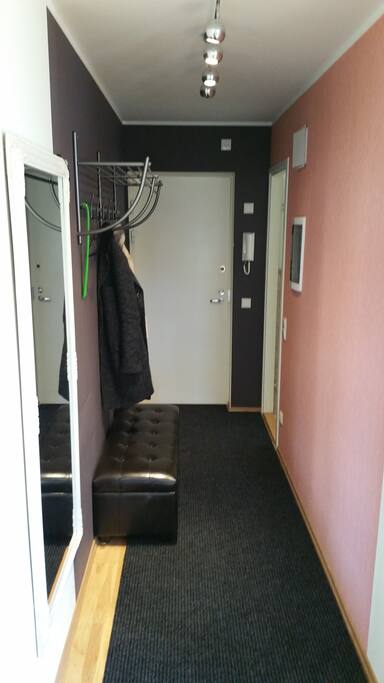 Hallway and front door. Entry to the bathroom in the right hand corner