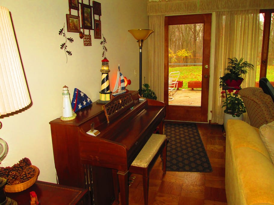 Piano in Living Room, Door to Large Deck Leading to Backyard