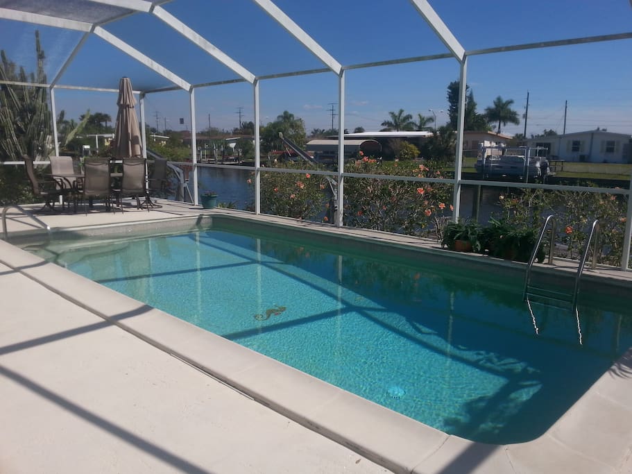 Pool overlooking canal with patio furniture