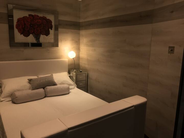 Bedroom with Double Hollywood Bed which has an electric Pop-up Smart TV.