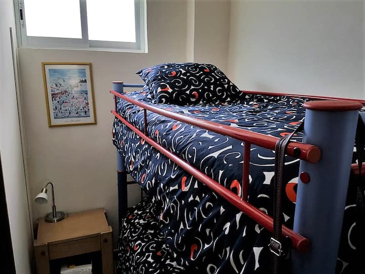 غرفة صغيرة بسرير بطابقين وحمام