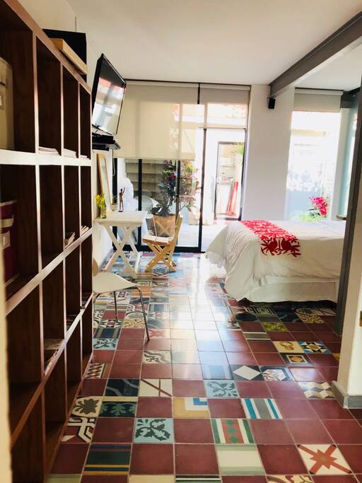 pasillo que conecta área de sofá cama con cama queen size