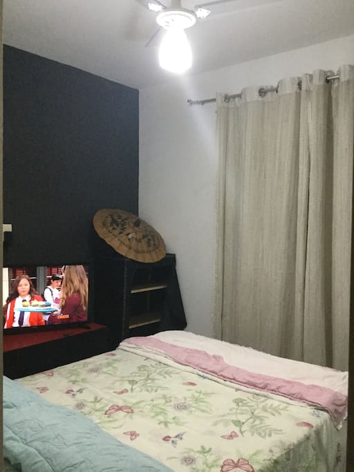 Quarto com ventilador de teto e refrigerador