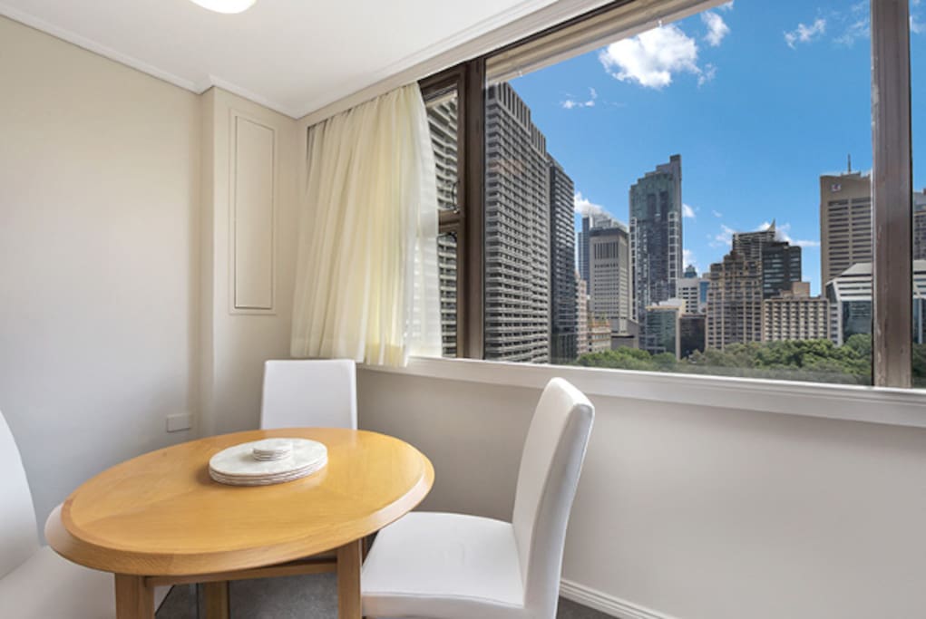 Large windows providing lots of natural light, dining table doubles as a work station.