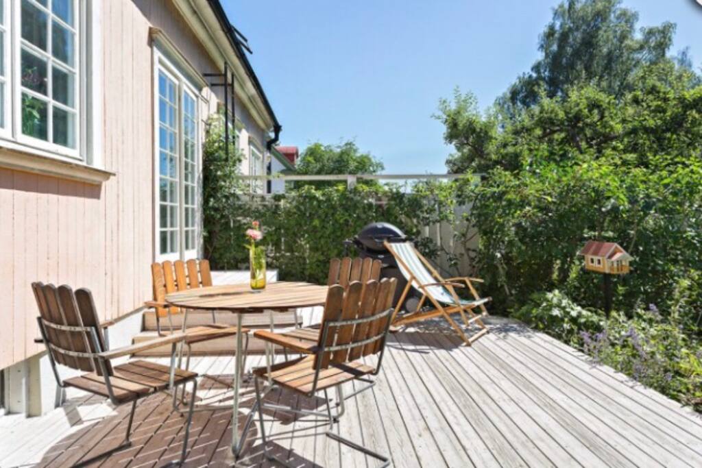 Solig härlig uteplats med sköna utemöbler och grill