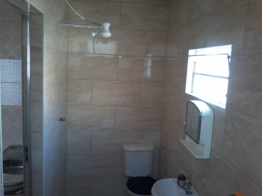 Banheiro novo. Chuveiro quente. sabonete, toalha de rosto e de banho.