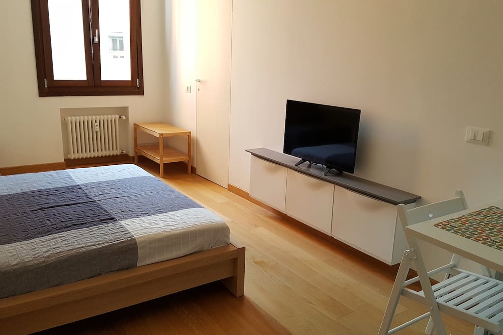 Il mobile TV, di fronte al letto e visibile anche dal tavolo