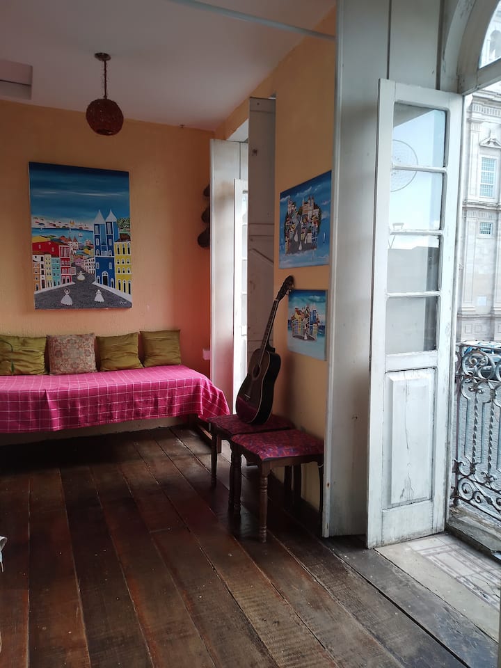 Obývacia izba je vzdušná s okennými dverami a balkónmi, aby ste si mohli vychutnať exkluzívny panoramatický výhľad na námestie, jeho architektúru a jeho ľudí.