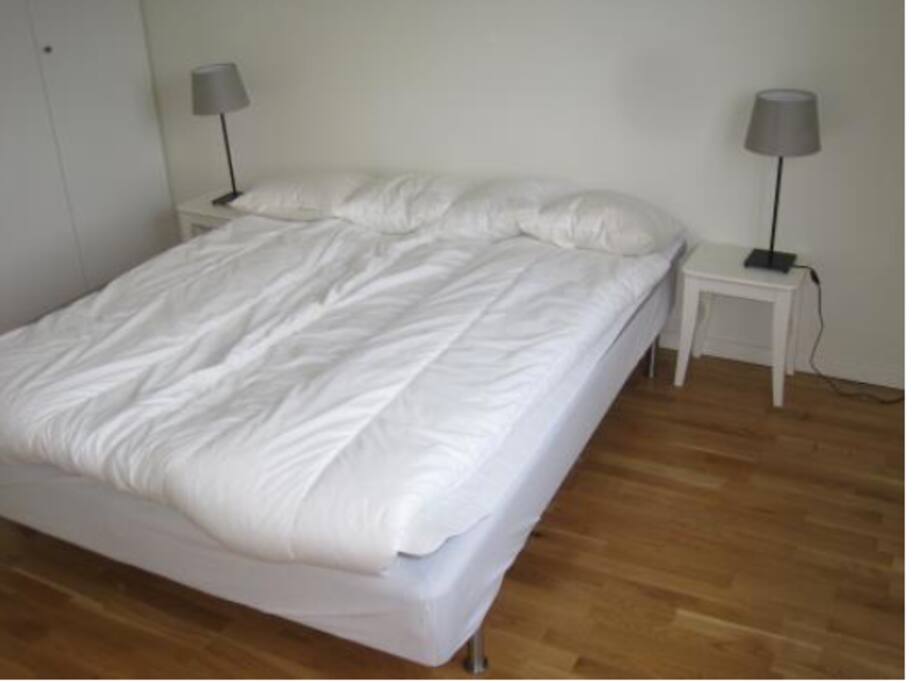 Double bed in bedroom with wardrobes.