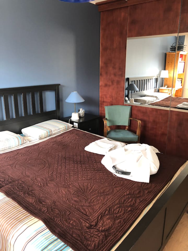 Dormitorio con cama tamaño queen 160x190, toallas de baño,