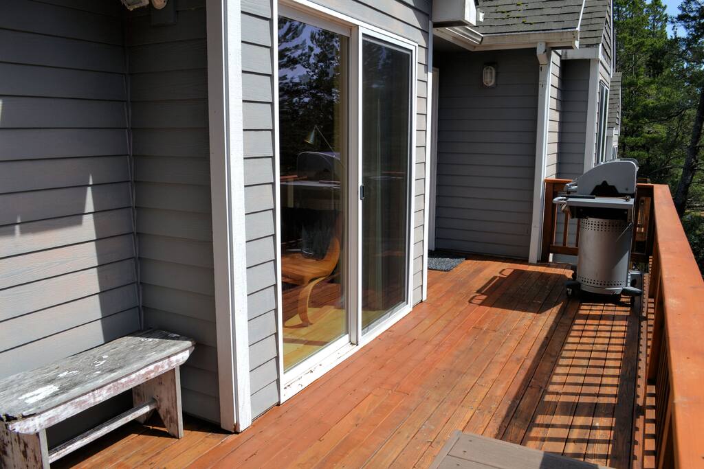 Upper deck off living area with a bench seat and gas BBQ