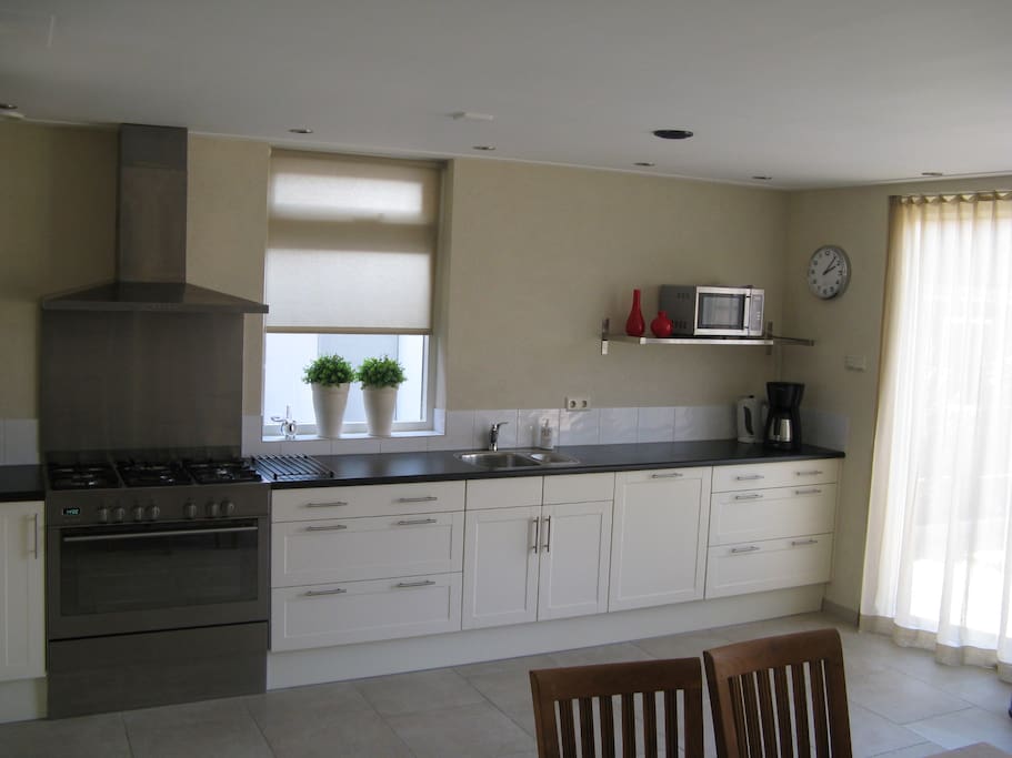 Ruime keuken met vaatwasser, magnetron, groot fornuis met oven , koelkast/ vriezer