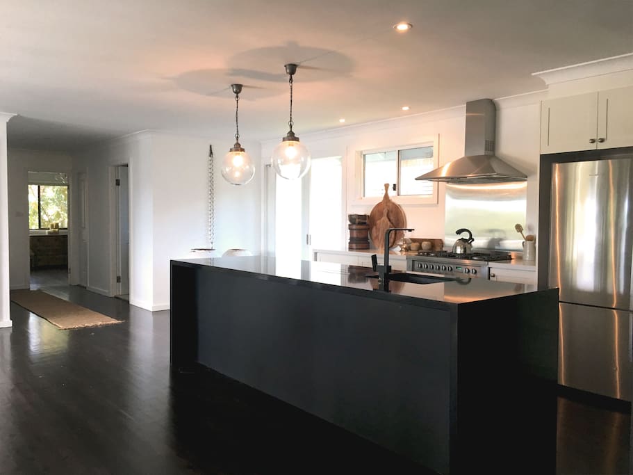 Modern monolithic black stone island kitchen with industrial stove –a gourmand's dream.