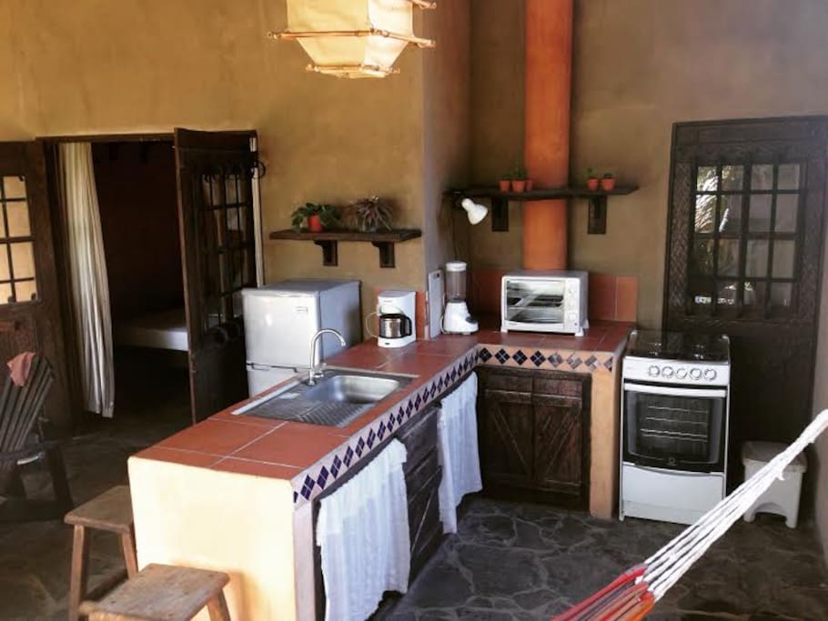 Kitchen with fridge/freezer, gas stove/oven, electric toaster oven, coffee maker and blender.
