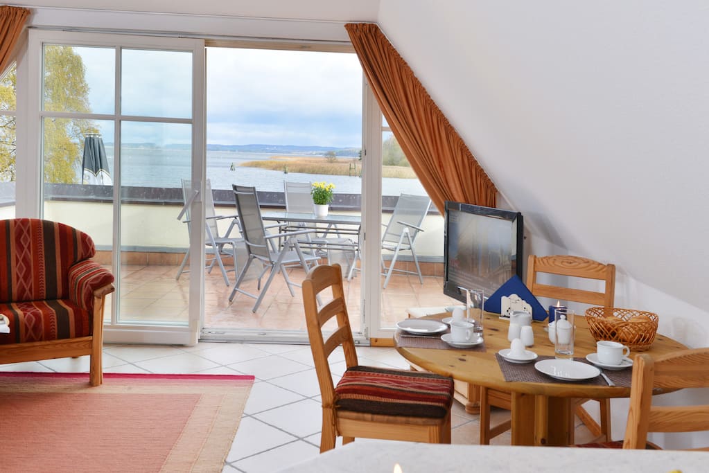 Wohnzimmer mit Eßplatz und Blick auf den möblierten Balkon