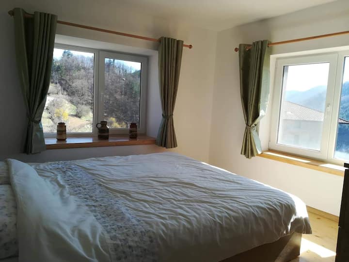 Camera da letto principale con doppio aspetto e vista sulle montagne da entrambe le finestre