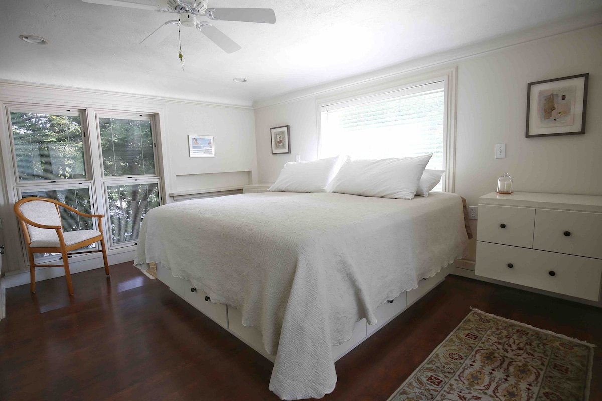 King bedroom, surrounded by windows and up in the trees.