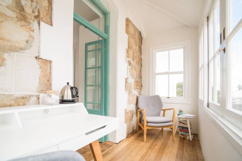 The adjoining private sunroom shows the beautiful features of this historical house -exposed stone walls and original wood flooring