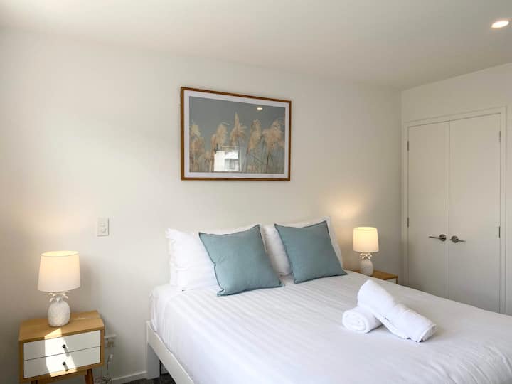 Bedroom with bedside lamps and a built-in wardrobe.