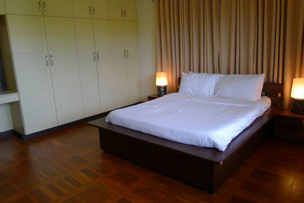 Master bedroom has a queen-sized bed with a cozy comforter and blackout curtains.
