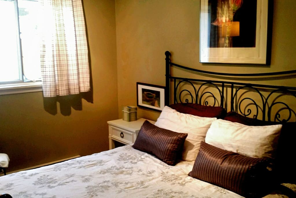 Bedside table, dresser, closet, storage, hangers, TV, window fan, and laundry basket.