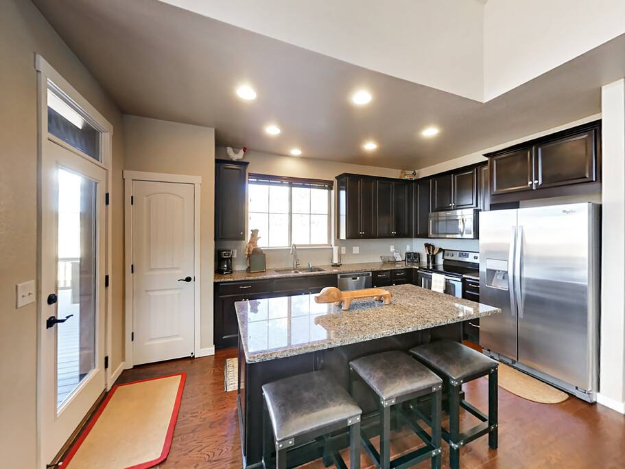 This gleaming granite kitchen has an island with bar seating for 3.