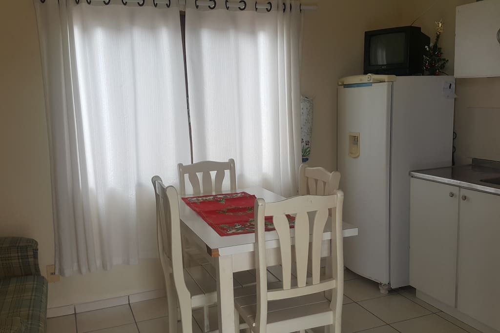 Cozinha com geladeira, fogão, TV, pia